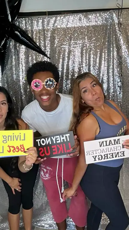 Boomerang of three guests posing with props